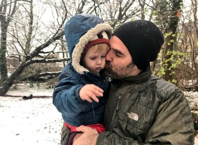 Rob Delaney kissing his son Henry on the cheek while they stand outside in the snow