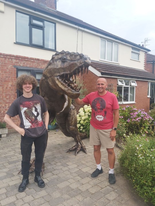 PIC FROM Kennedy News and Media (PICTURED: MATTHEW RIDDELL-ROVIRA, 20, WITH DAD DAVE ROVIRA, 56, AND THEIR GIANT T-REX SCULPTURE ON THEIR DRIVEWAY) A dad gave his dinosaur-mad son a 21st birthday present he'd never forget - a 7ft tall T-REX statue that 'roars' at his neighbours from the driveway. Matthew Riddell-Rovira saw homeware shop Miola, in Holmes Chapel, Cheshire, was closing down and selling its iconic metal dinosaur sculpture. When he asked dad Dave Rovira to buy it the 56-year-old was going to reject the 'wild' idea but mum Blanch Rovira thought it'd make a great early 21st birthday present. DISCLAIMER: While Kennedy News and Media uses its best endeavours to establish the copyright and authenticity of all pictures supplied, it accepts no liability for any damage, loss or legal action caused by the use of images supplied and the publication of images is solely at your discretion. SEE KENNEDY NEWS COPY - 0161 697 4266