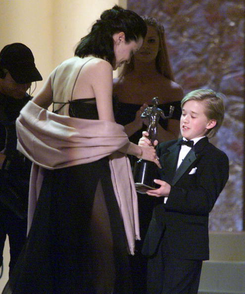 US actress Angelina Jolie (L) accepts her award from Haley Joel Osment