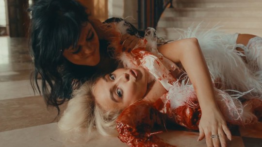 Jenna Ortega wrestling Sabrina Carpenter, covered in fake blood, in the music video Taste