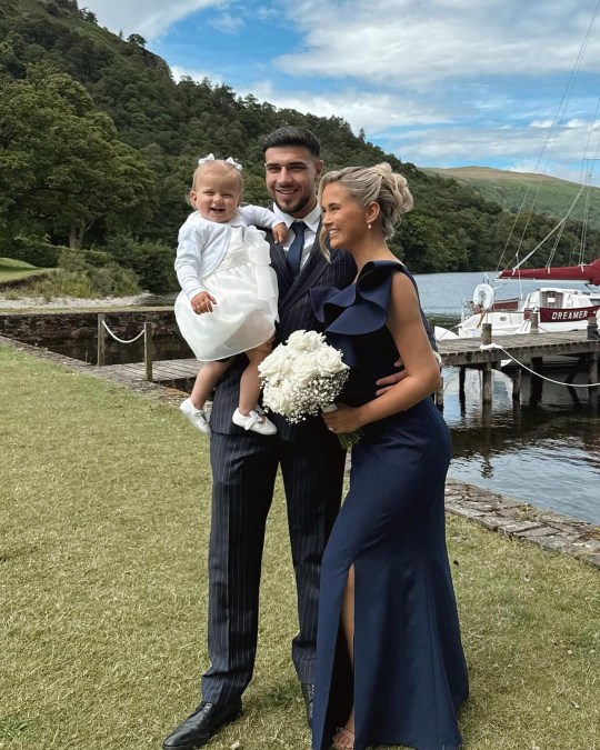 Tommy Fury and Molly-Mae Hague pictured holding their daughter Bambi at a wedding.