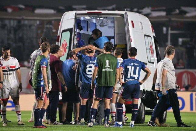 Uruguayan footballer Juan Izquierdo is taken away in an ambulance after collapsing on the pitch