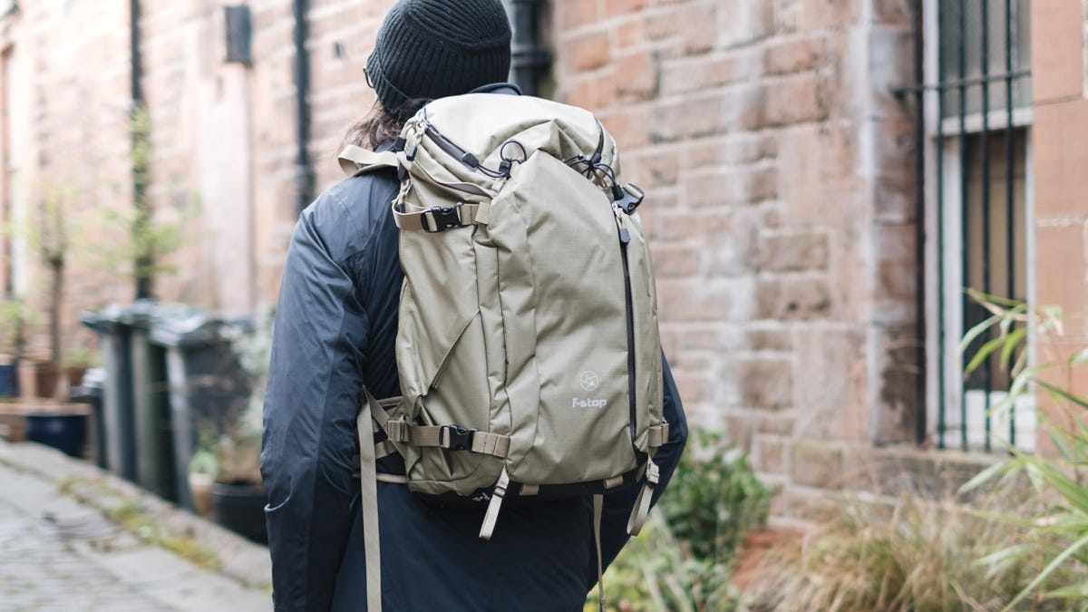 A person wearing a backpack-style photography bag