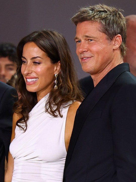 Brad Pitt and Ines de Ramon with their arms around each other at Venice Film Festival