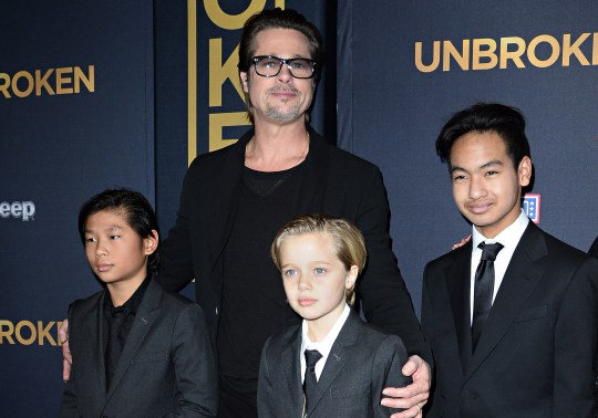 Brad Pitt posing with three of his children