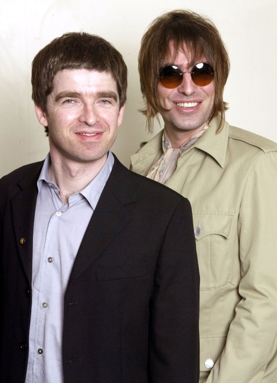 Liam and Noel Gallagher smile together in the earlier days of Oasis