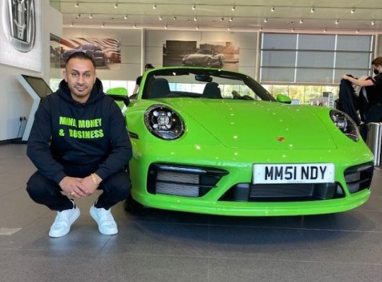 Mindy crouched down next to his green porsche