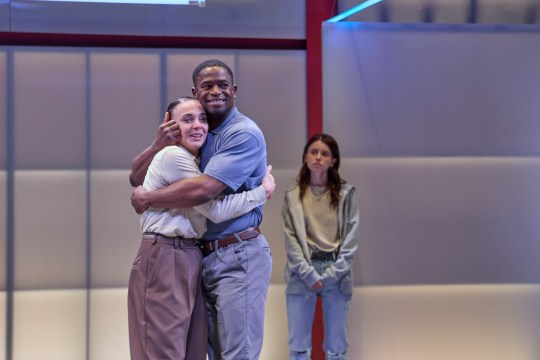 Amanda Abbington hugs co-star on stage during production of When It Happens to You at the Park Theatre. Another actor leans on wall in background.