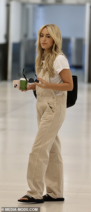 She toted her essentials in a black shoulder bag and enjoyed a hot drink