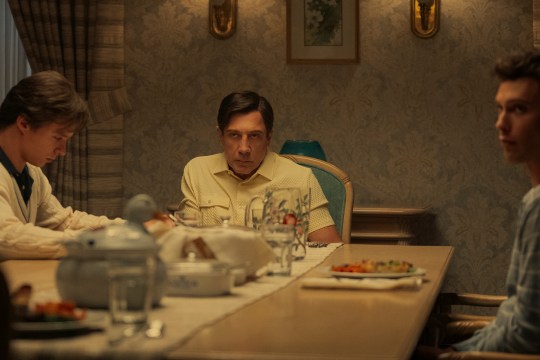 Nicholas Chavez as Lyle Menendez, Javier Bardem as Jose Menendez and Cooper Koch as Erik Menendez sitting at a dinner table in a scene from Monsters.