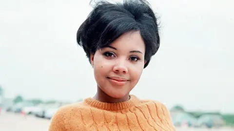 ITV/Shutterstock Cleo Sylvestre wearing an orange jumper, in an undated image 