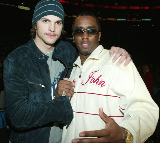 Sean 'Diddy' Combs and Ashton Kutcher embrace at the NBA All-Star Game in 2004