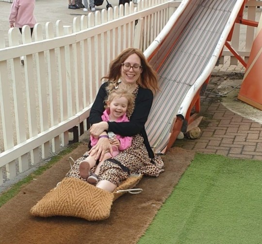 Dr Emily Cooper on a slide with her daughter.