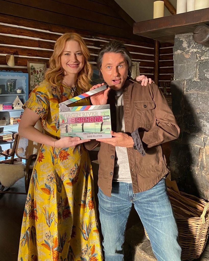 Alexandra Breckenridge and Martin Henderson holding clapperboard