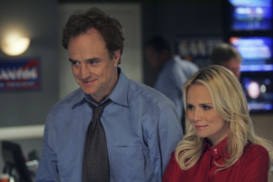 (l-r) Bradley Whitford as Josh Lyman, Kristin Chenoweth as Annabeth Schott smiling, with blurry screens behind them