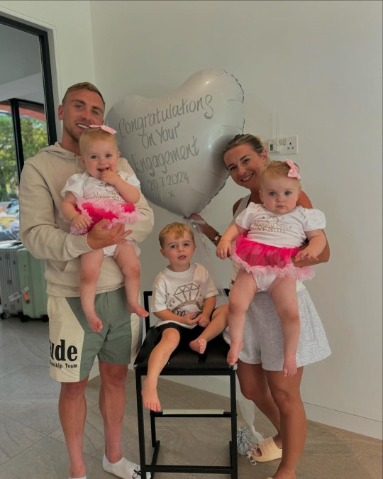 Dani Dyer and Jarrod Bowen announce engagement, posing with three children and balloon with 'congratulations'.