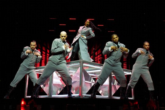 Janet Jackson performing on stage with dancers