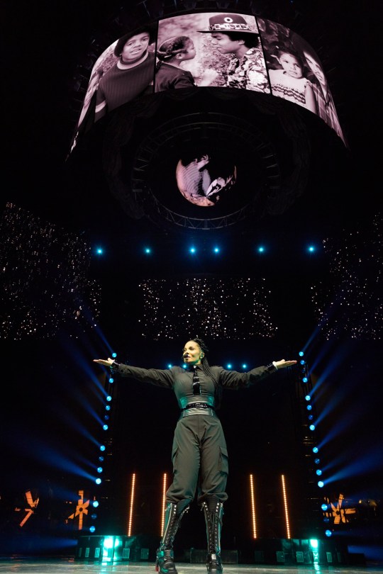 Janet Jackson standing on stage with a tribute to Michael Jackson, Tito Jackson and Joe Jackson