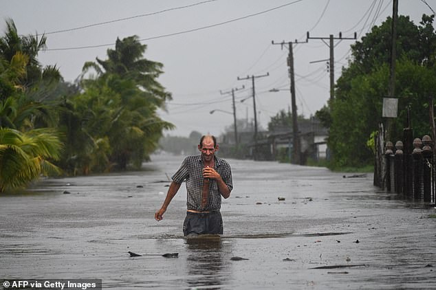 A resident of the coastal town of Guanimar, southwest of Havana, Cuba wades through a flooded street after the passage of Hurricane Helene this Wednesday, September 25, 2024