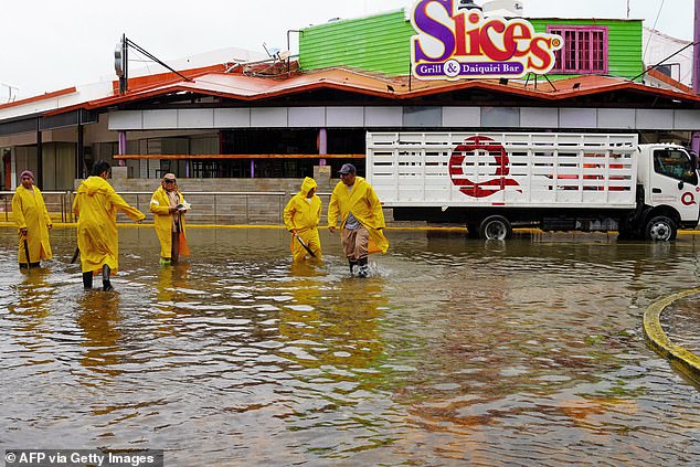 Above, people on a flooded street after Hurricane Helene made landfall in Cancun, Quintana Roo State, Mexico, on Wednesday assess the damage outside a grill and daiquiri bar