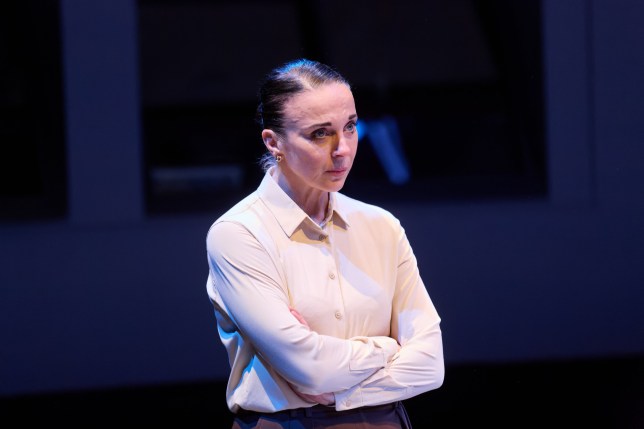 Amanda Abbington crosses arms on stage in When It Happens to You at the Park Theatre. She wears white shirt and hair is scrapped back.