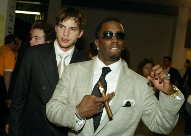 Sean 'Diddy' Combs and Ashton Kutcher at the MTV Movie Awards in 2003, both wearing suits and with Diddy holding a cigar