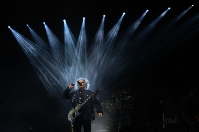 The Cure singer performing on a dark stage under lights at the OVO Arena Wembley