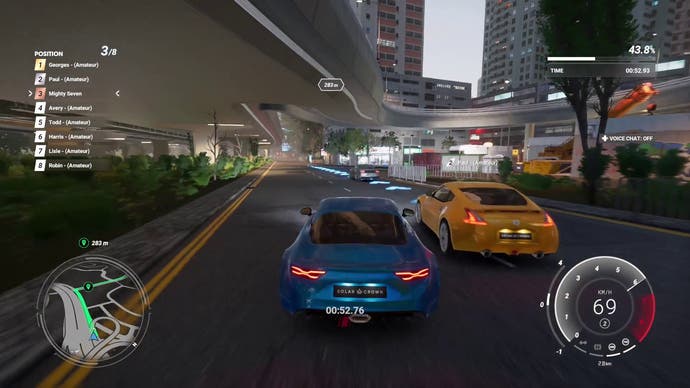 Test Drive Unlimited Solar Crown screenshot showing a race between an Alpine A110 Legende GT and a Nissan 370Z as they drive under a concrete overpass.