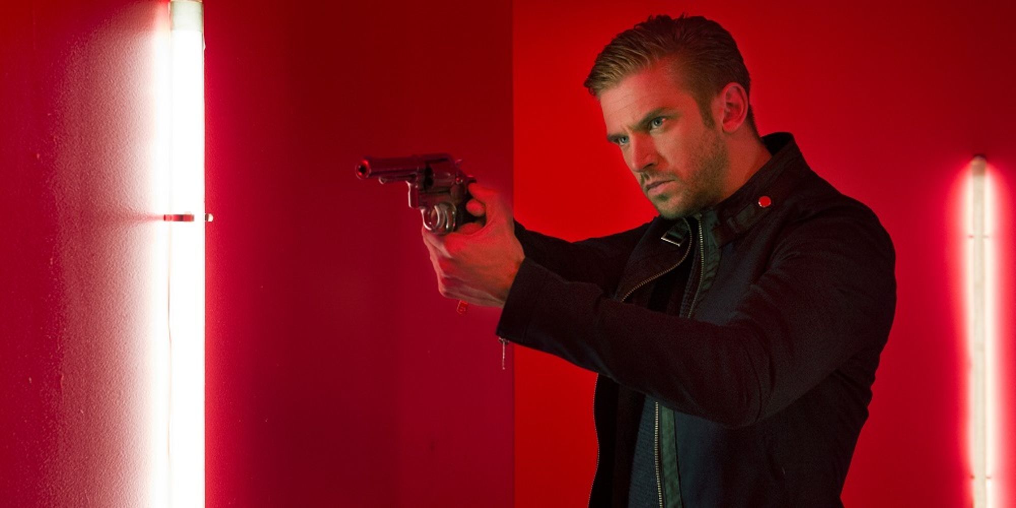 Dan Stevens holding a gun in The Guest