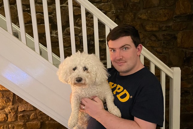 Jack holding Dudley at home, in front of a stair banister