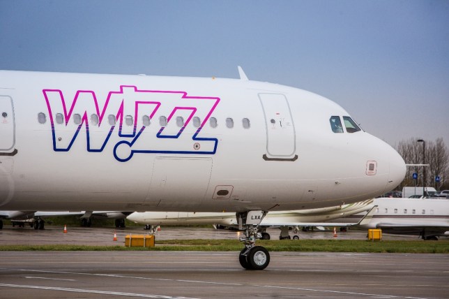 A Wizz Air Airbus A321 plane on a runway. 