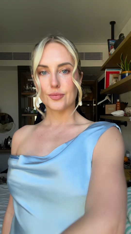 Emily Valentine poses for a selfie in a blue dress