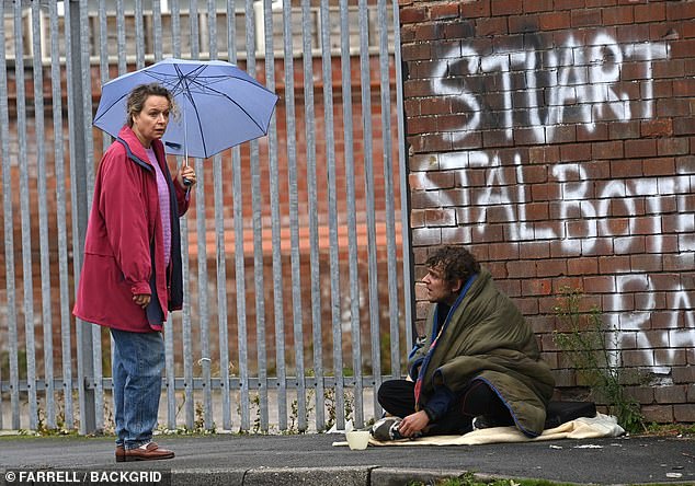 In another behind the scene image, Samantha's character - still wearing the same outfit - starts talking to a man who is seemingly living on the streets, wrapped up in a duvet, with a pot for money out in front of him