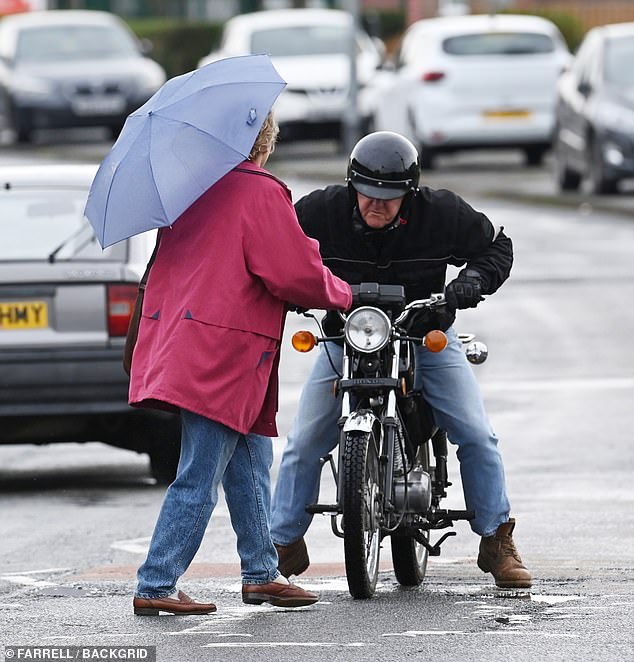 With a brown satchel flung over her shoulders, she turns to face the driver before gesticulating with her arms, as if to say 'What are you doing?'