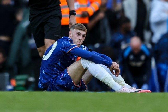 Cole Palmer sat on the pitch during Chelsea's match against Brighton