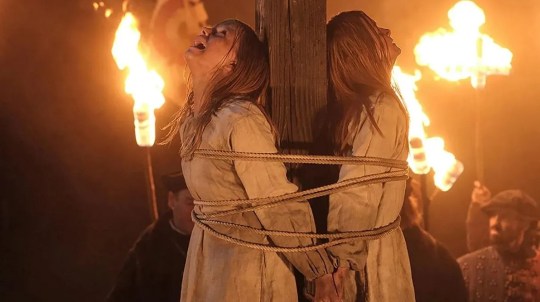 Two young girls being burned at the stake in a scene from The Burning Girls.