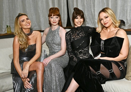 Nadine Coyle, Nicola Roberts, Cheryl and Kimberley Walsh of Girls Aloud sitting together at an event. They are all smiling and wearing formal gowns