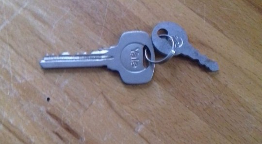 A set of keys on a wooden surface.