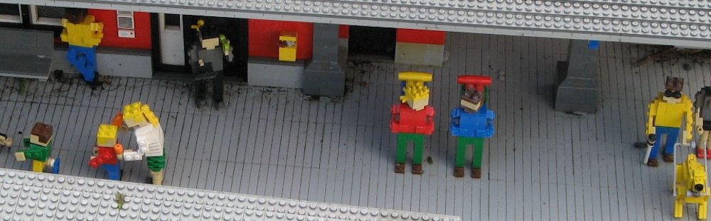 Lego figures standing on a station platform