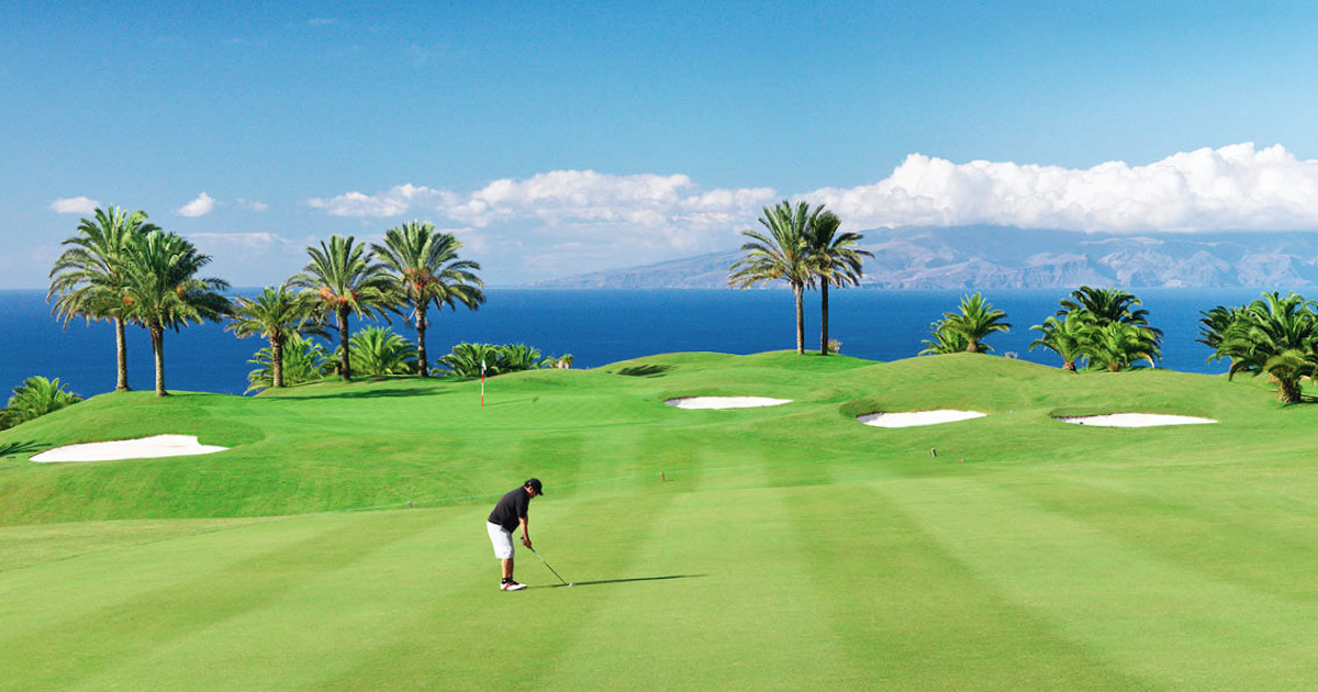 Panoramaudsigt over grøn golfbane i det sydlige Spanien med Middelhavet og blå himmel