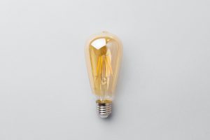 Light bulb on light grey paper background