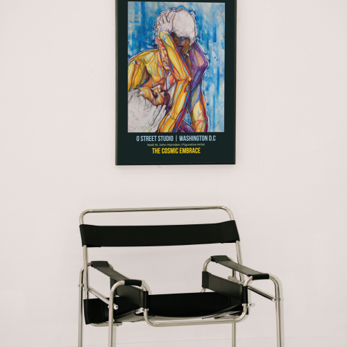 CITY SERIES O STREET STUDIO WASHINGTON D C THE COSMIC EMBRACE IN A BLACK FRAME HUNG ON A WALL IN FRONT OF A WASSILY CHAIR