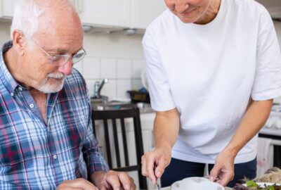 man i rutig skjorta som blir serverad mat av en kvinna i vit t-shirt