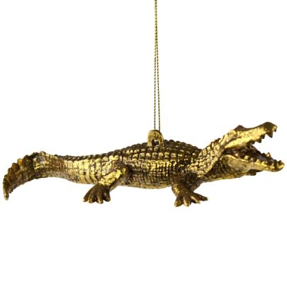 Guldfarvet ornament formet som en krokodille. Krokodillen står har åben gab.