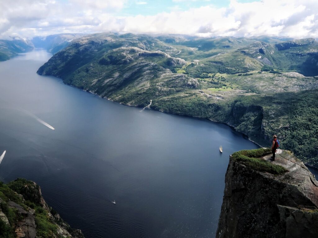 friluftsliv- lifestyle and hiking in norway, person standing on a mountain top with view of the lysefjord