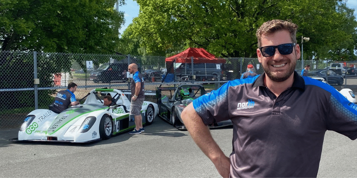 Sam North standing in front of a race car.