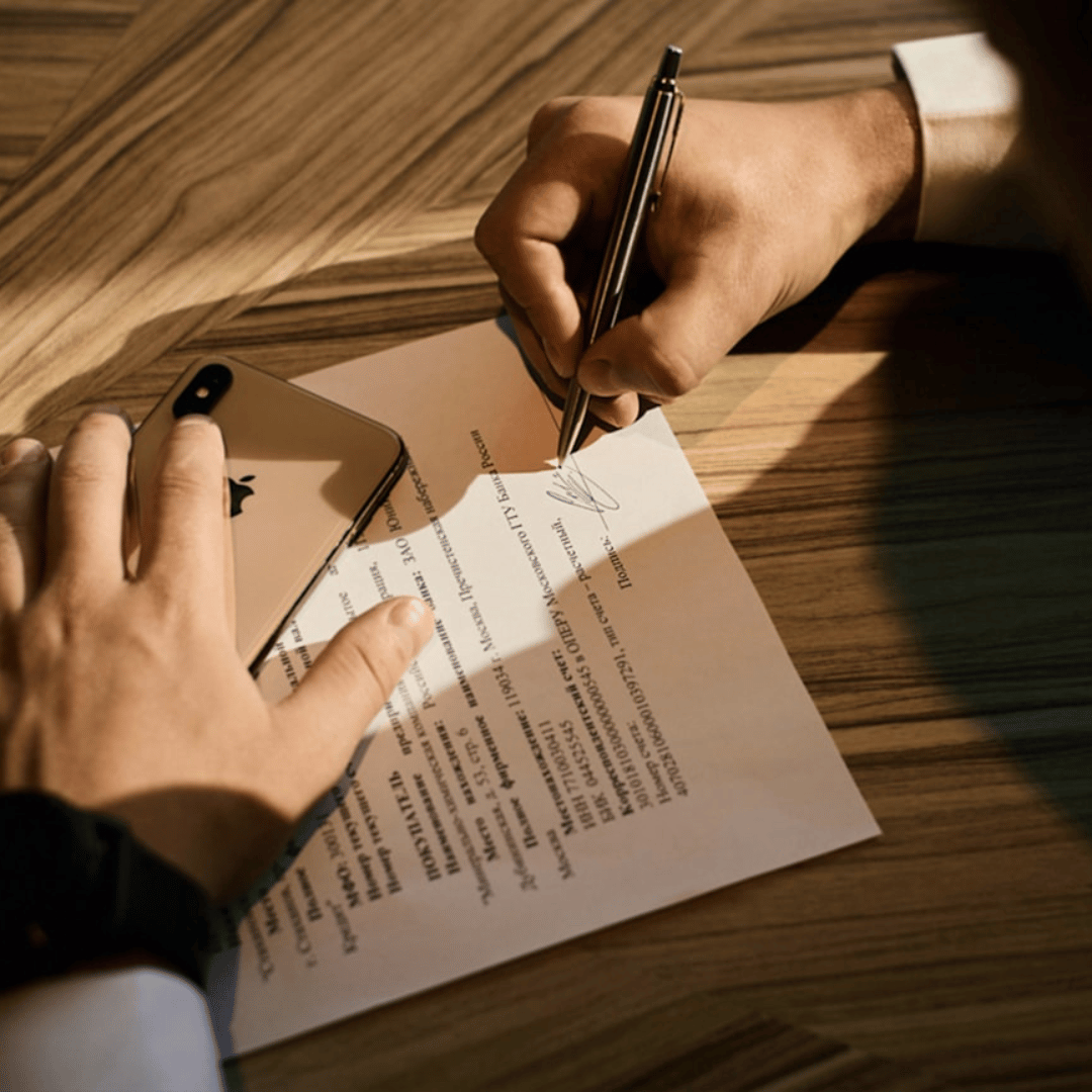 A person signing an affidavit in the presence of a notary public, highlighting the process of notarization in the UK