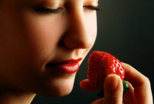 Mujer comiendo fresas como parte de una alimentación consciente