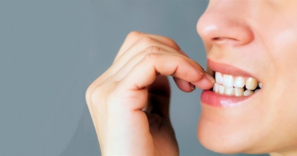 Fotografía de ansiedad por comer y comer por ansiedad que muestra una mujer comiéndose las uñas