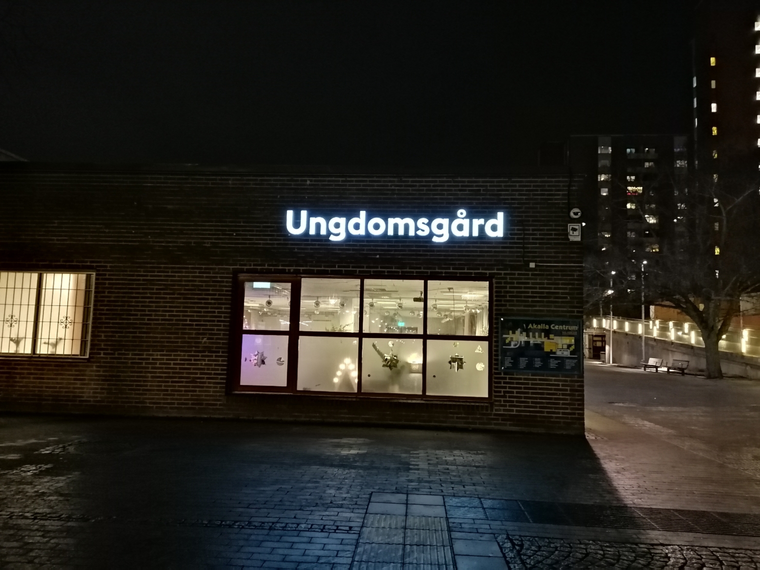 byggnad i mörkret med "Ungdomsgård" i neonbokstäver